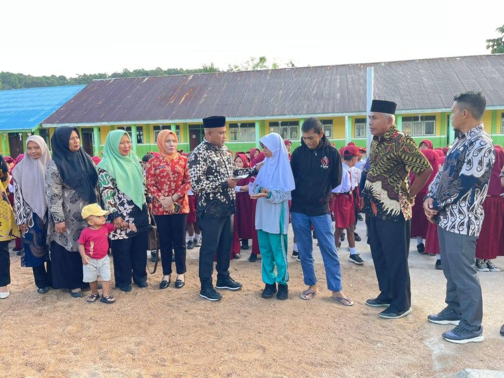 Kepala Dinas Pendidikan saat menyerahkan santunan kepada kedua anak korban di Sekolah