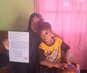 Istri dan anak Bripda FF saat memegang surat pernyataan perjanjian