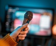 woman holding microphone front tv 260nw 2693010975